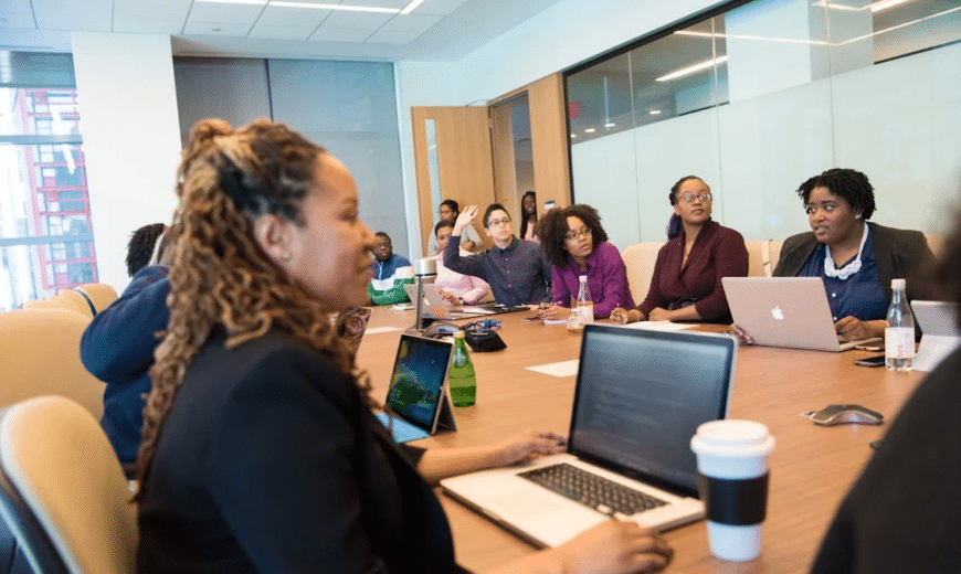 A group of people seated at a wooden conference table