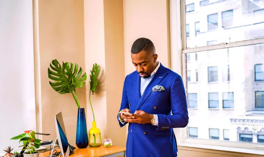 A man standing, wearing a blue suit