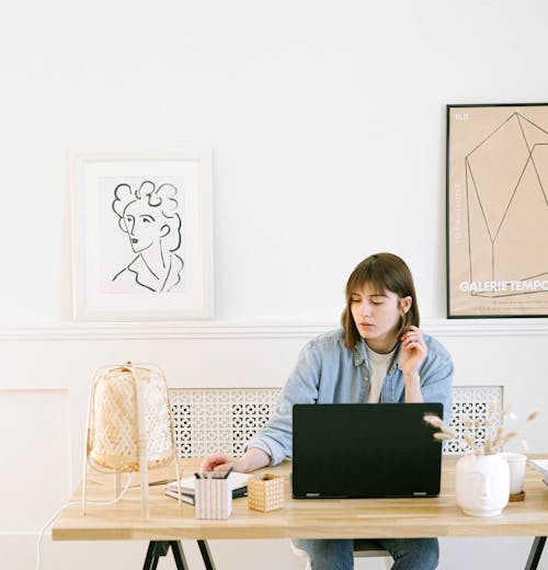 A woman sitting at a desk, with a laptop open