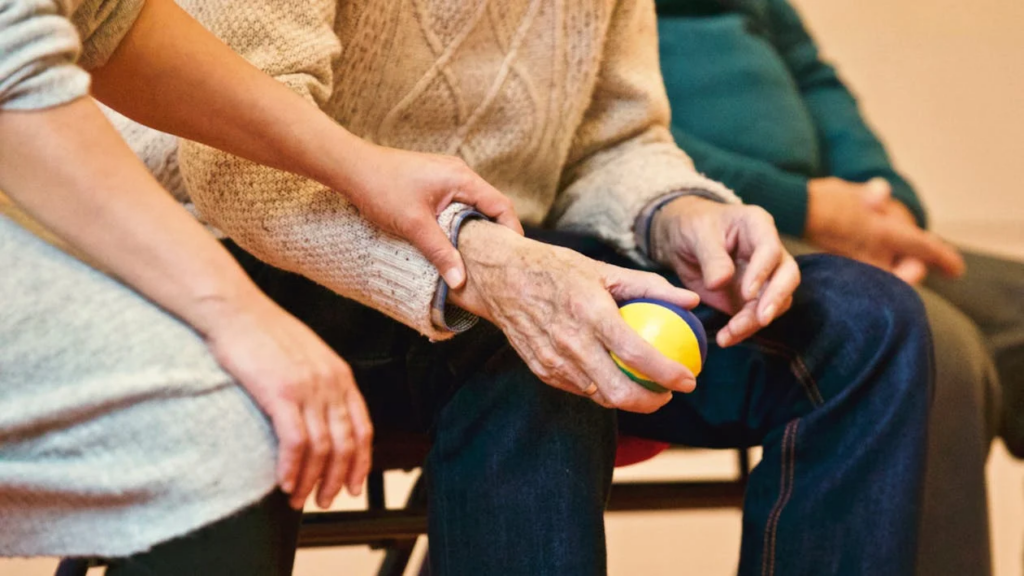 A hand holding an elderly person’s arm 