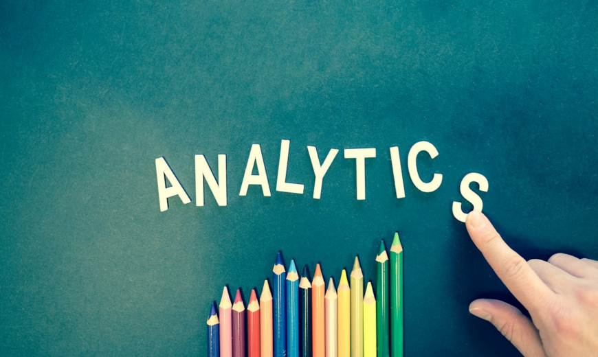 Letting spelling out the word analytics next to colored pencils