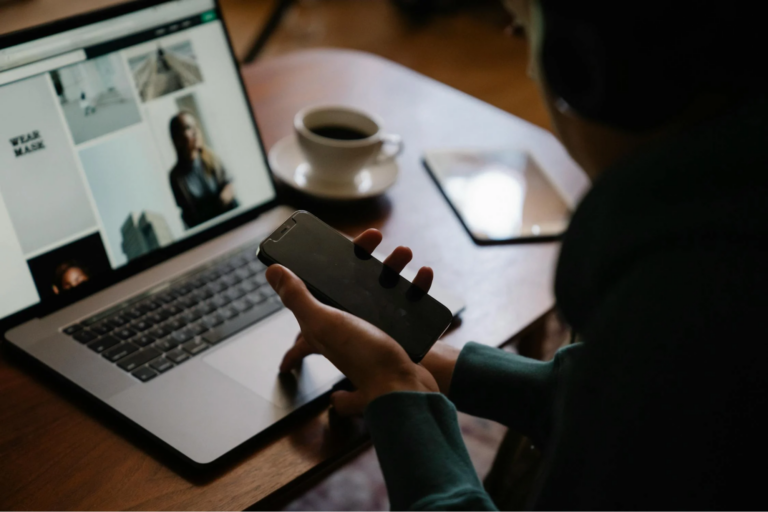 A man using a laptop and smartphone